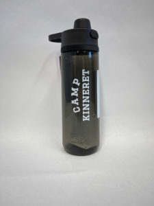 A black water bottle with "Camp Kinneret" written in white text on the front. The bottle features a black screw-on cap with a carrying handle.